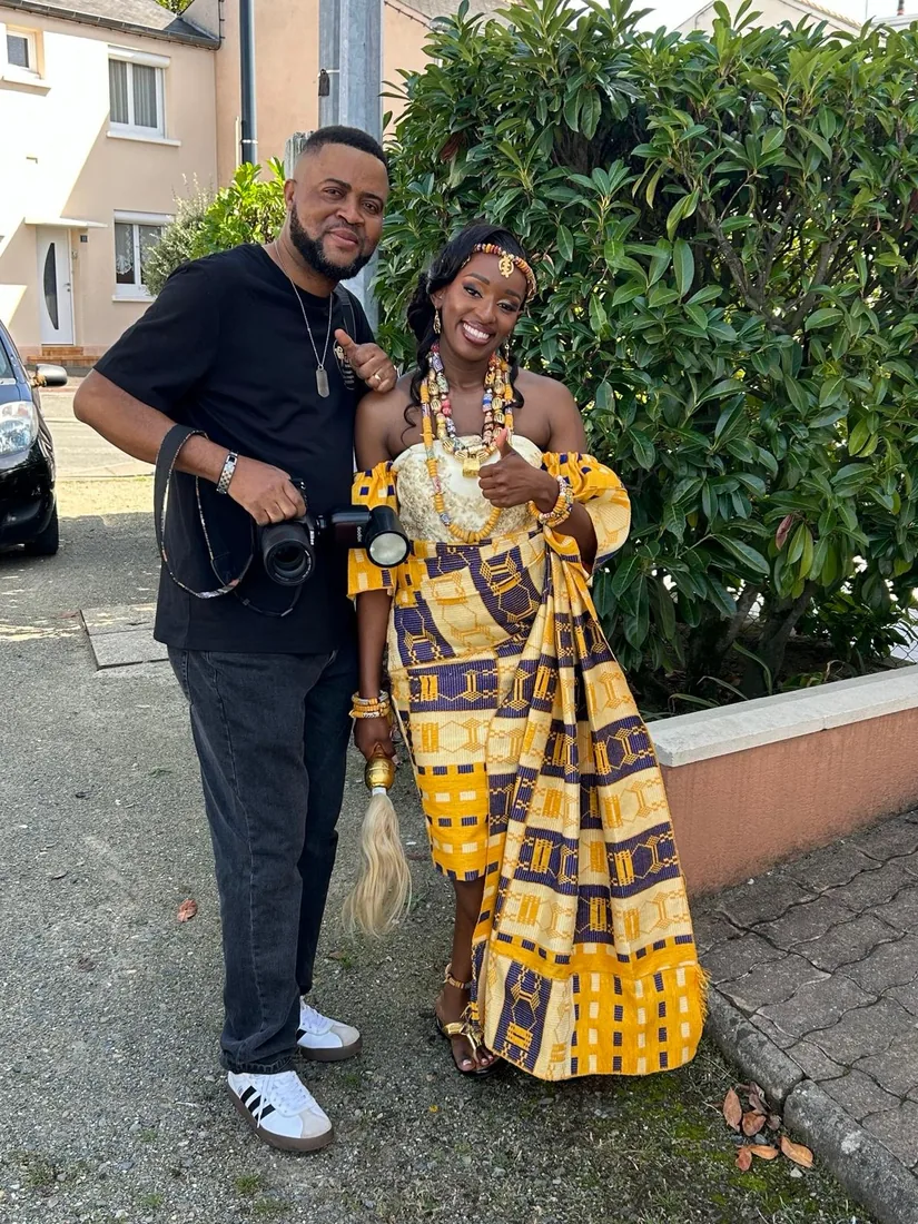 Eddy Ngongo, appareil photo à la main, aux côtés d'une mariée en tenue traditionnelle